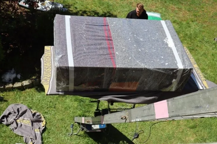 verpacktes grosses moebelstueck auf moebellift im garten